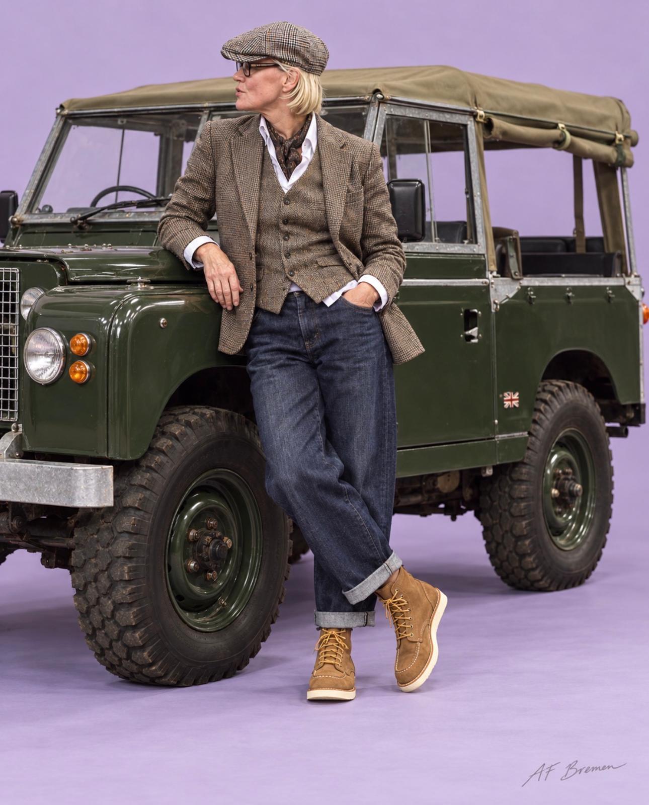 AF Bremen Look mit dreiteiligem Tweed-Outfit, Schiebermütze und Denim am klassischen Geländewagen